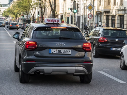 Grauer Audi Q2 Fahrschulwagen mit Kennzeichen BF NL 3333 im normalen Stadtverkehr von hinten gesehen.